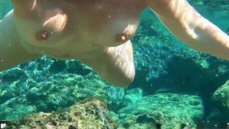Hot MILF undressing under water and swims naked in the sea with pussy closeup