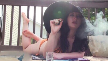 Bikini Babe Smokes Outside In A Sunhat